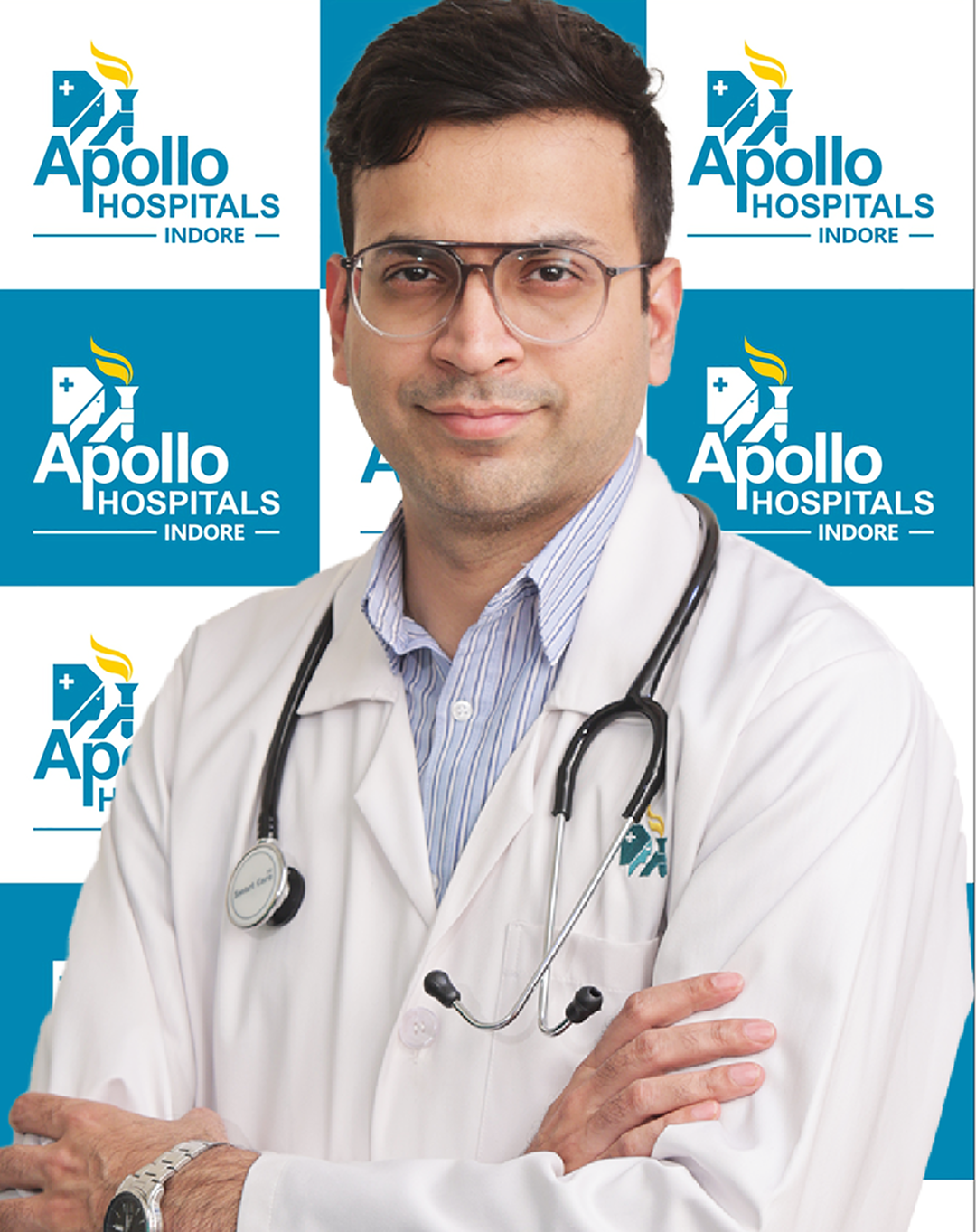 A male doctor wearing a white coat and stethoscope, standing confidently in front of a branded Apollo Hospitals Indore background, looking directly at the camera.