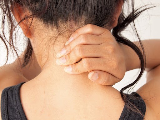 Woman touching back of neck demonstrating neck pain or lymph node swelling symptom of cancer for patient awareness by Dr. Hozefa Lokhandwala best oncology specialist in Indore